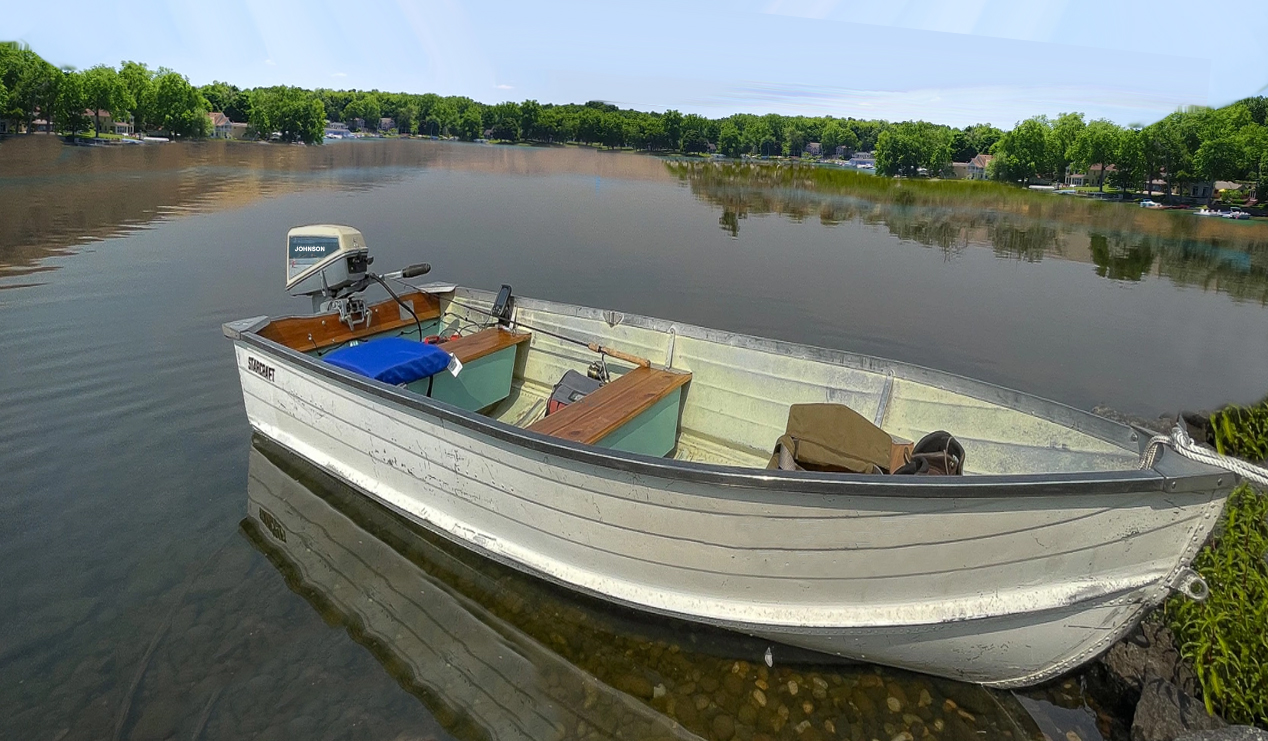 A simple 14-foot aluminum boat with a vintage outboard motor on Walled Lake.
