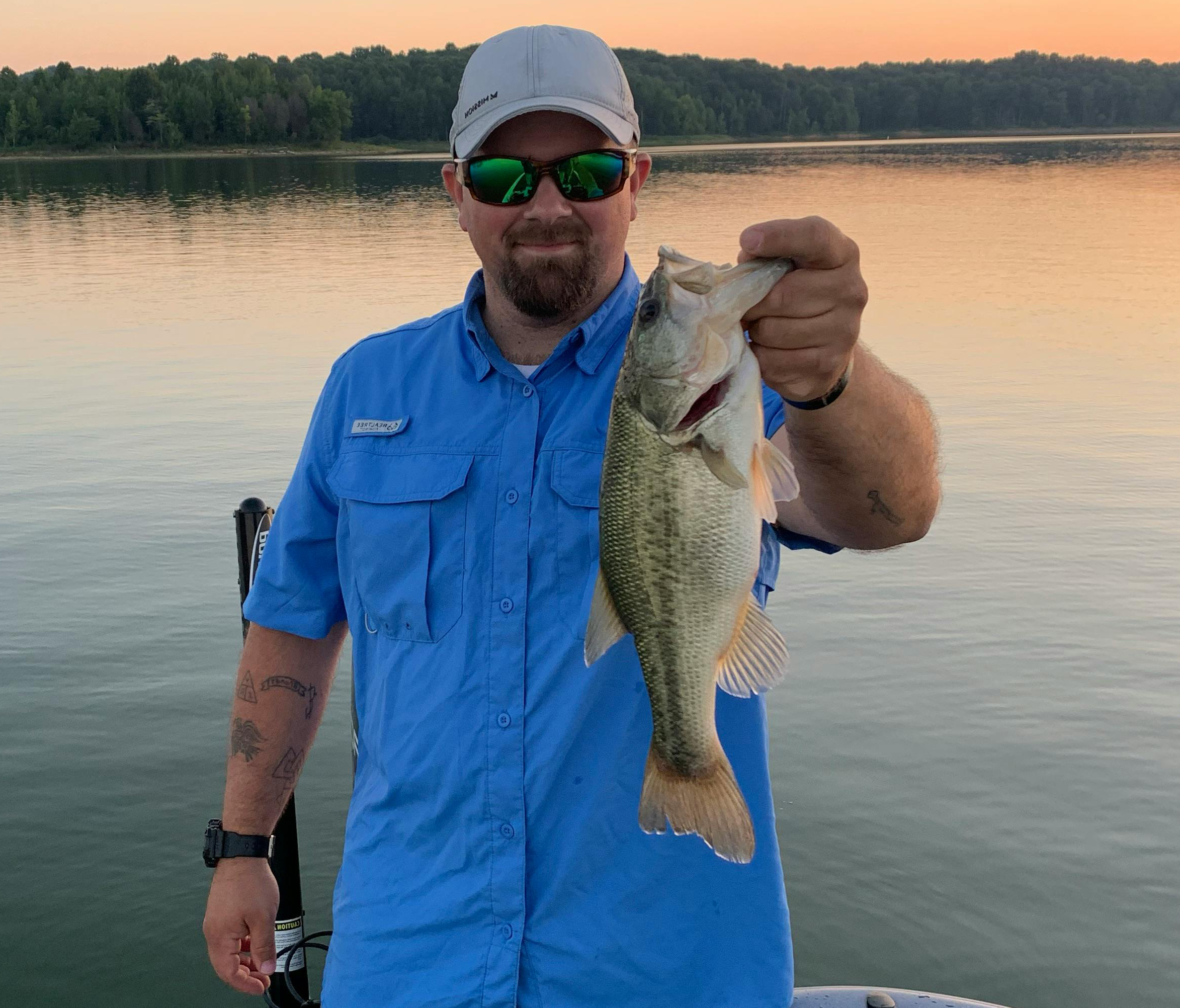 An angler with a casting rod and reel setup ideal for buzzbait fishing.