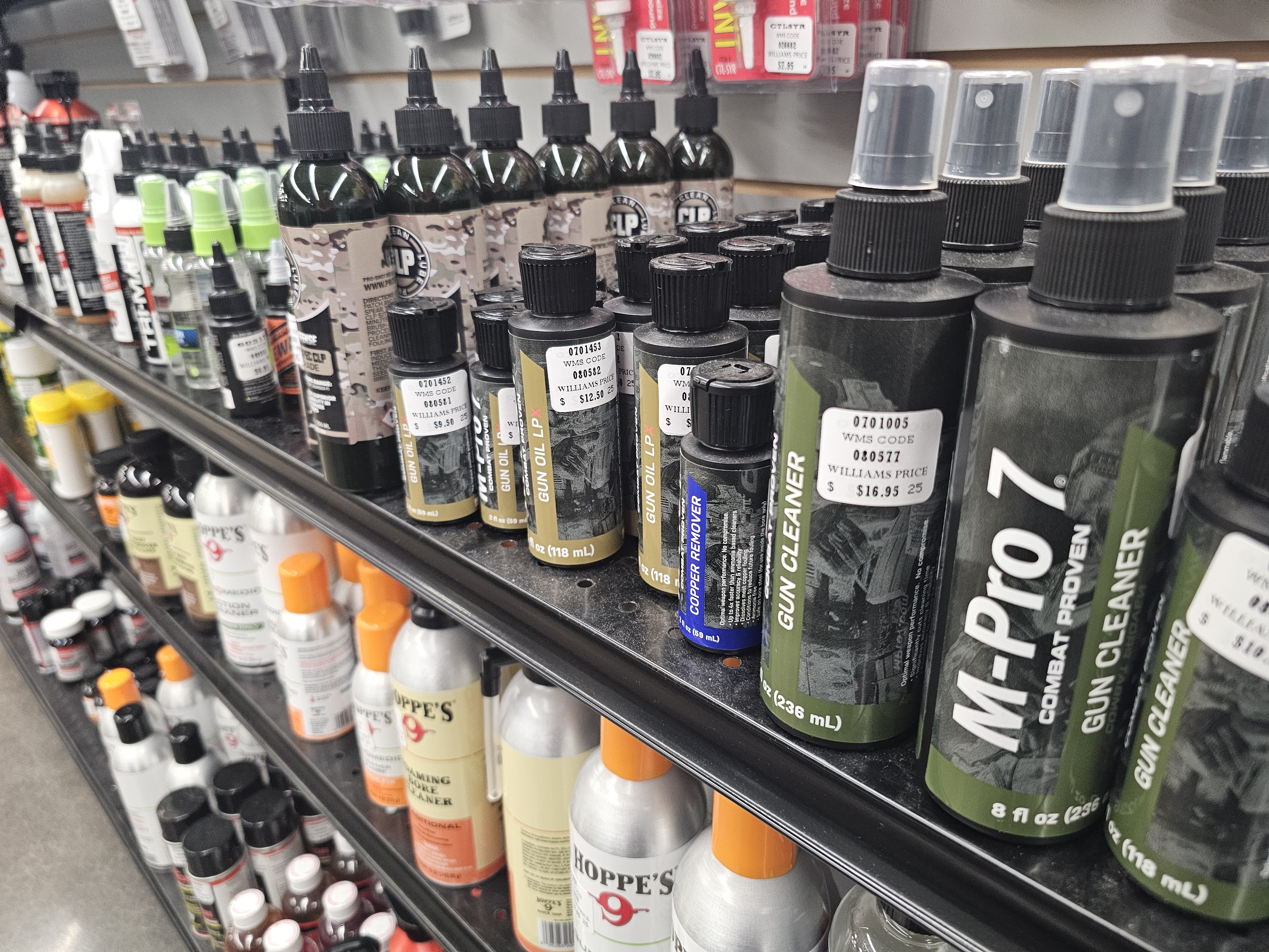 A store shelf full of gun cleaning supplies including solvents and oil