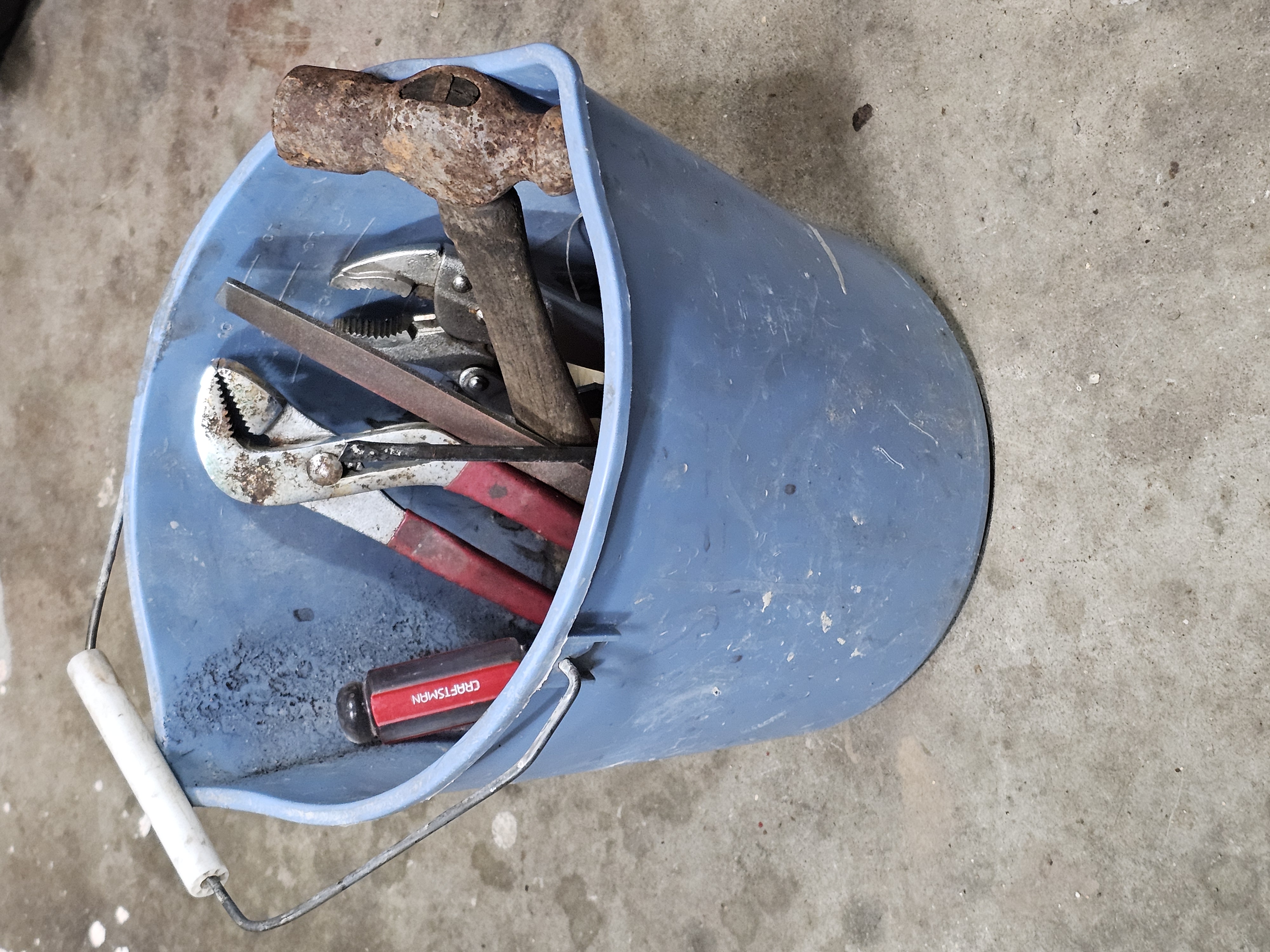 A bucket filled with tools necessary for on the go trap repairs.
