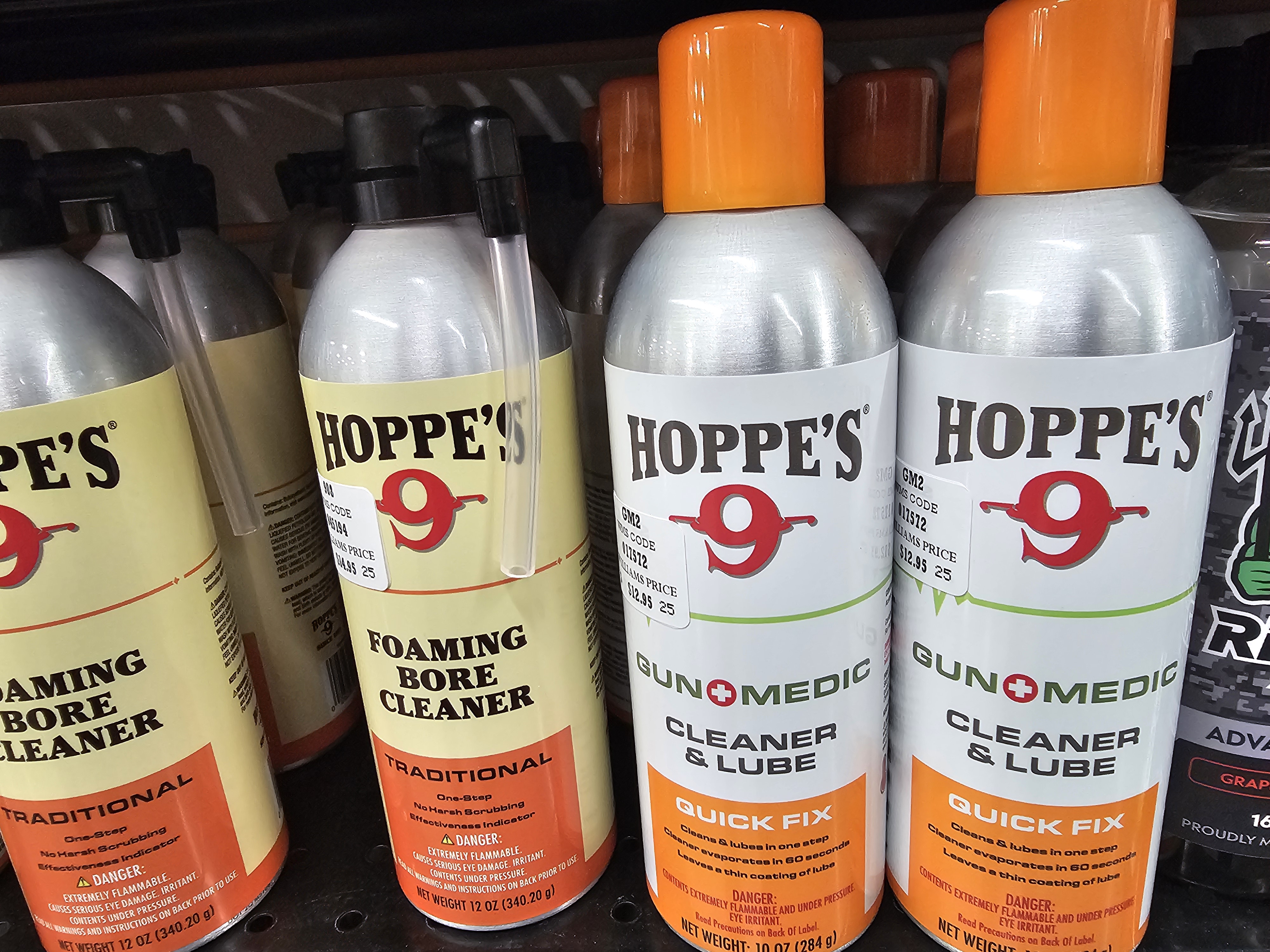 Hands holding a rifle bolt while spraying it with an aerosol gun cleaner